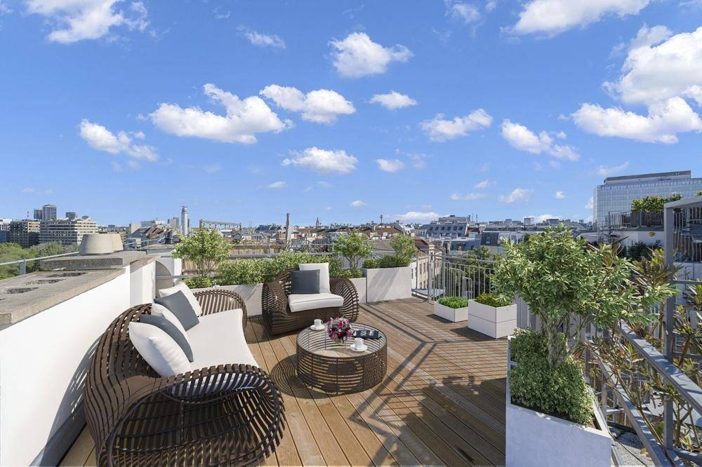Große Dachterrasse mit modernen Loungemöbeln und weitem Blick über die Stadt.