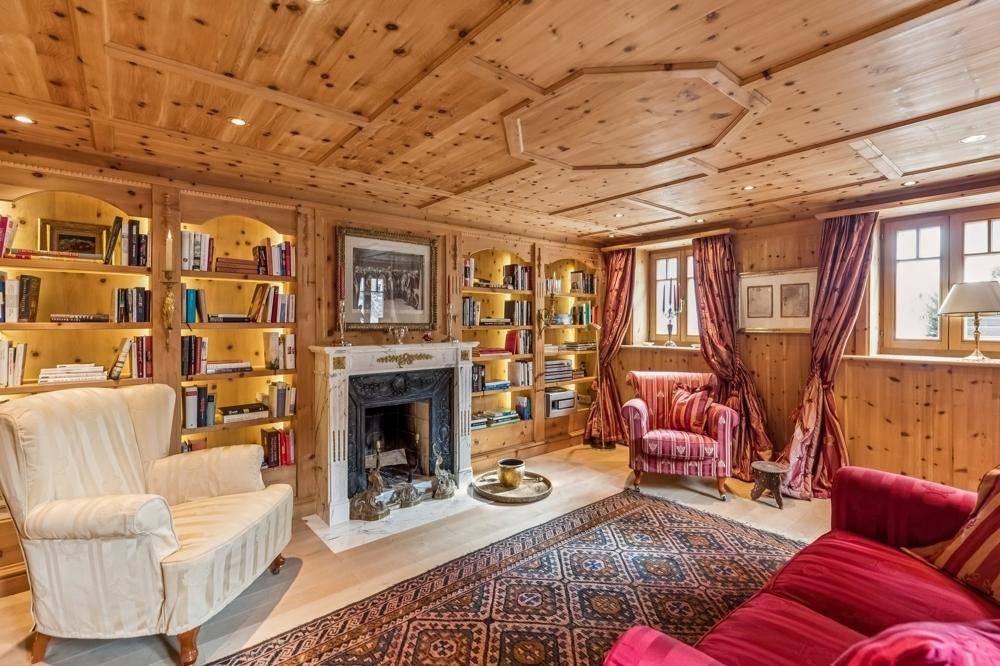 Elegantes Wohnzimmer mit Holzwänden, Kamin, integrierten Bücherregalen und traditionellen Möbeln.