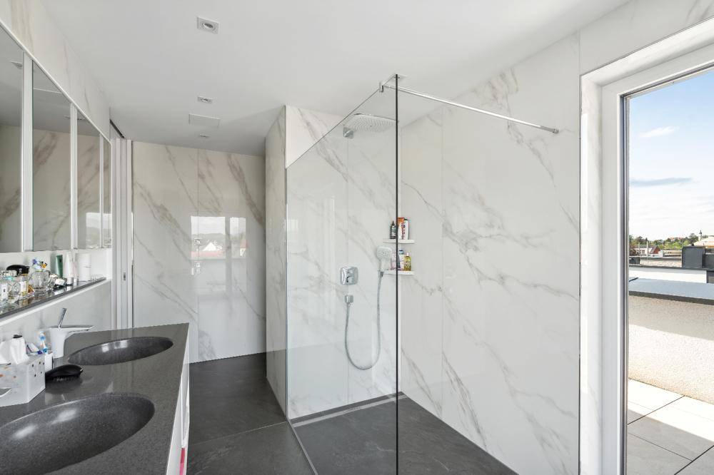 Modernes Badezimmer mit begehbarer Dusche, Doppelwaschbecken und Zugang zur Dachterrasse.