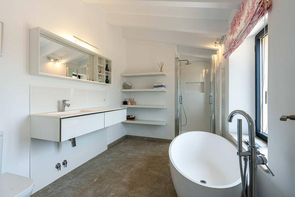 Modernes Badezimmer mit freistehender Badewanne, großer Dusche und Doppelwaschbecken.