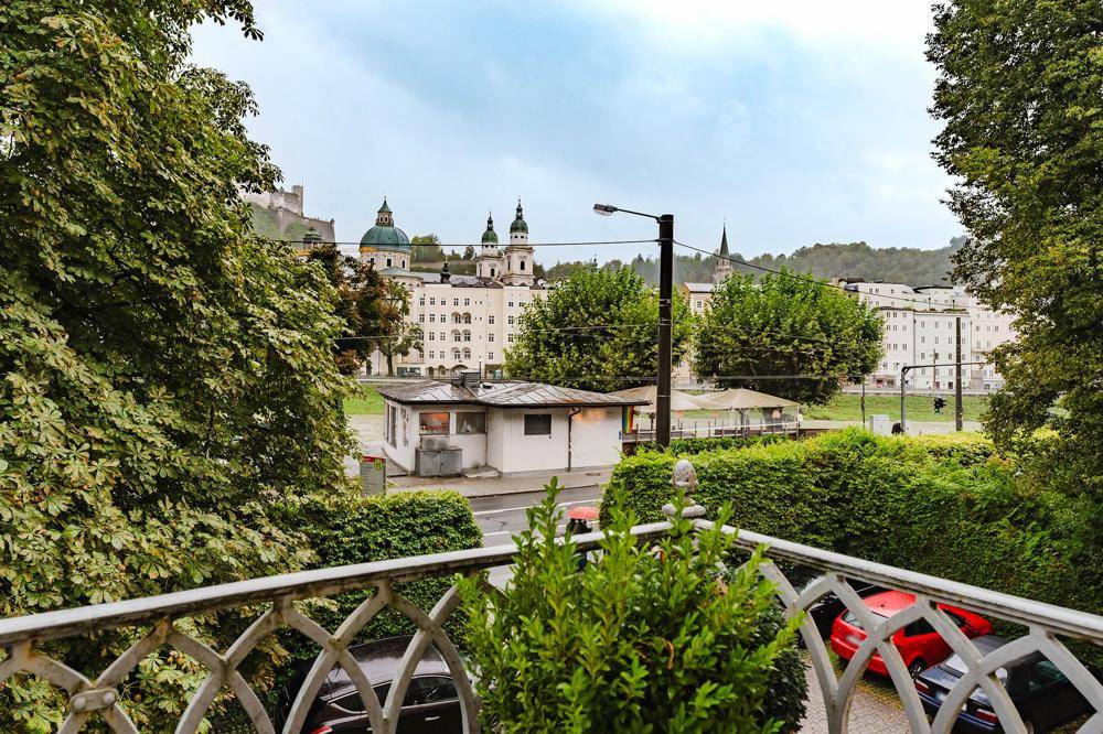 Balkon mit schmiedeeisernem Geländer und Blick auf die Stadt und die Festung Hohensalzburg.