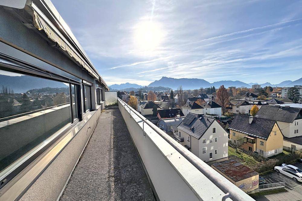 Sonniger Balkon mit weitem Blick über die Stadt und die umliegende Berglandschaft.
