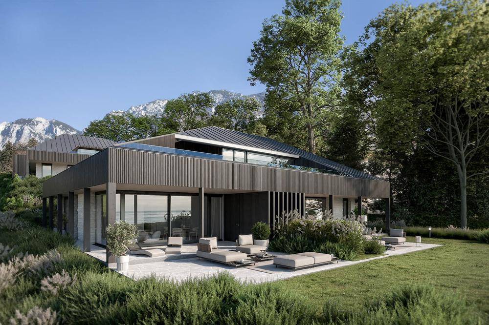 Moderne Architektur eines Hauses mit Flachdach und Dachpool, umgeben von viel Grün und Bergen.