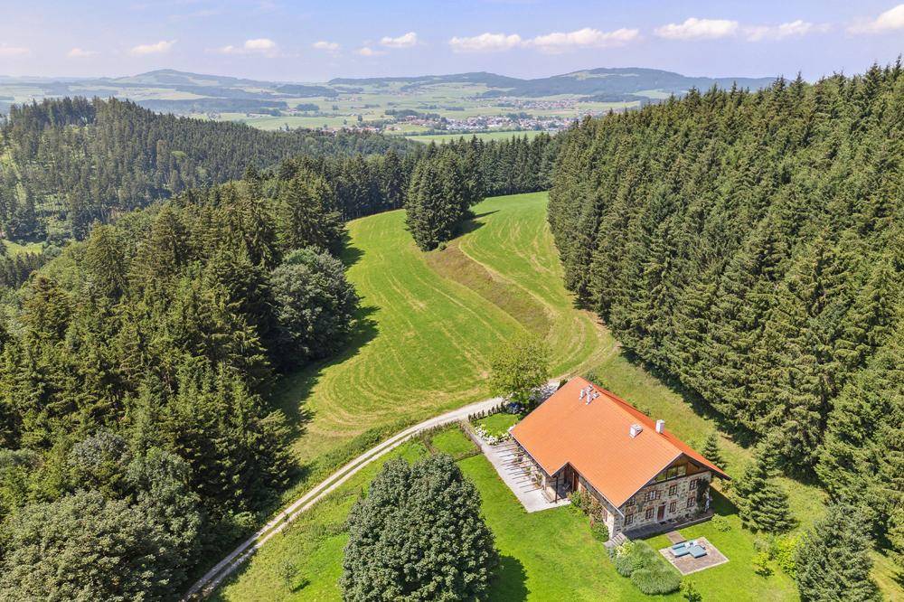 Luftaufnahme des Anwesens, eingebettet in eine grüne Landschaft mit Wäldern und Feldern.