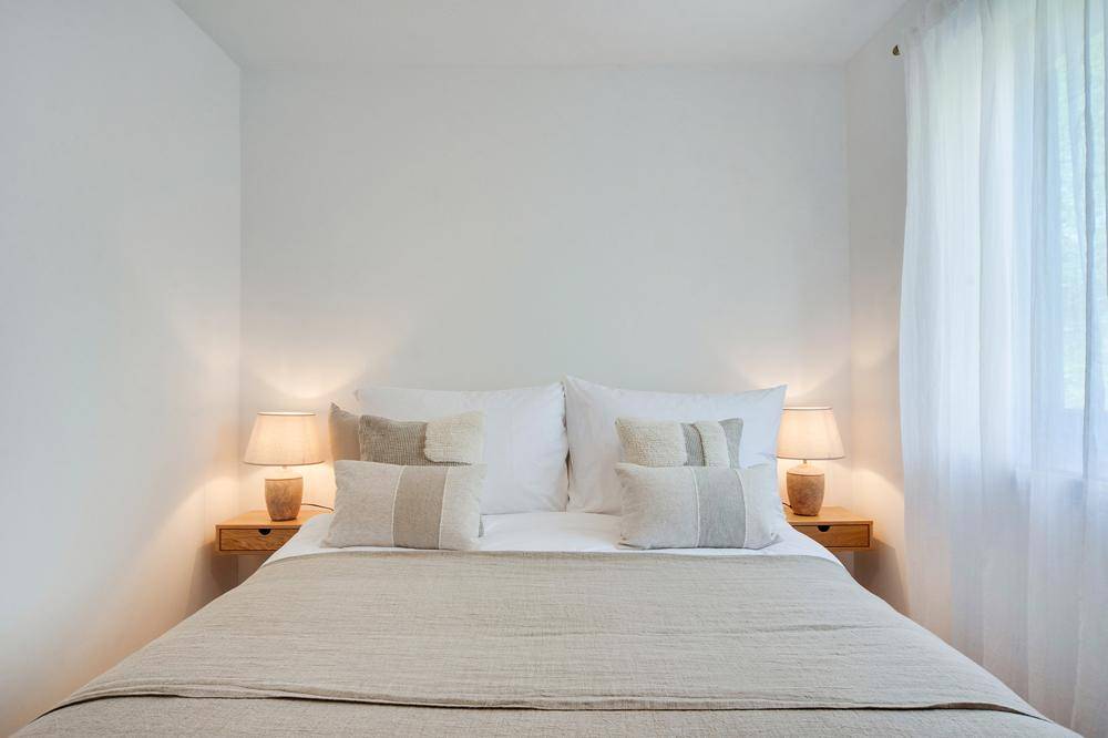 Gemütliches Schlafzimmer mit Doppelbett, Nachttischen und sanfter Beleuchtung.