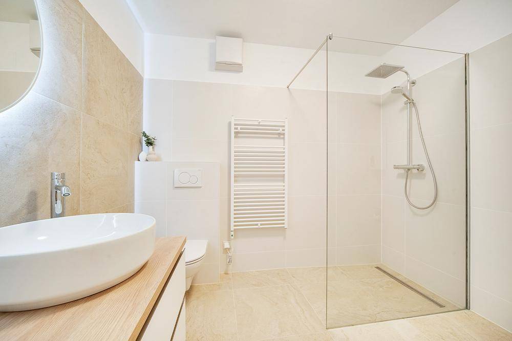 Modernes Badezimmer mit begehbarer Dusche, Wand-WC und stilvollem Waschbecken.