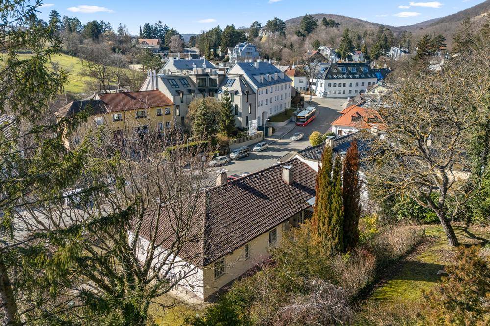 Panoramablick auf das Anwesen und die umliegende Wohngegend mit Hügeln im Hintergrund.