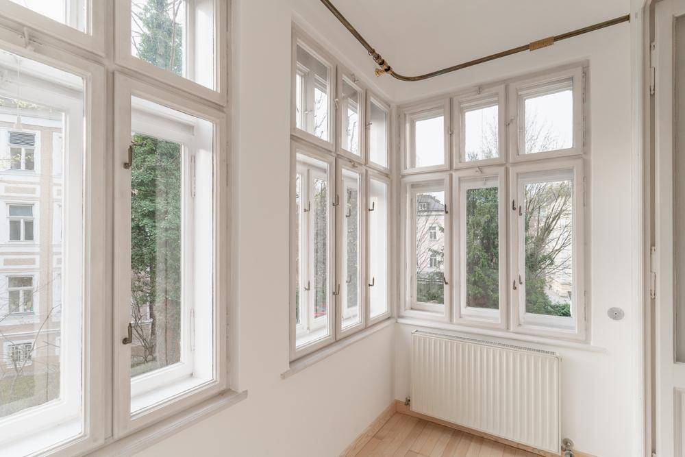 Erkerbereich mit vielen Fenstern und Heizkörper, bietet viel Tageslicht und Ausblick.
