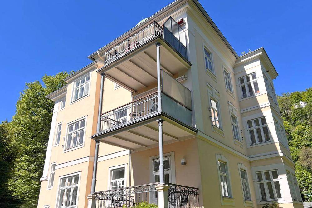 Elegantes Mehrfamilienhaus mit mehreren Balkonen und klassischer Architektur.