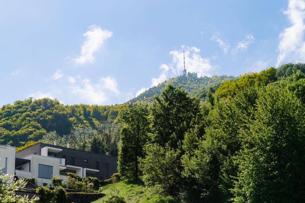 Moderne Architektur eingebettet in eine grüne Hügellandschaft mit Fernblick auf einen Sendeturm.