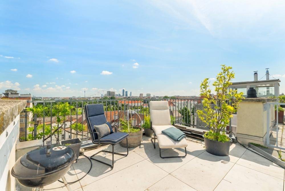 Großzügige Dachterrasse mit Liegestühlen, Grillbereich und beeindruckendem Stadtpanorama.