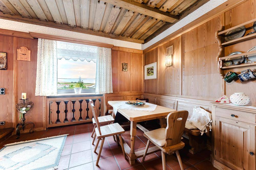 Gemütlicher Essbereich im alpenländischen Stil mit Holzvertäfelung, rustikalen Möbeln und eingebauten Bänken.