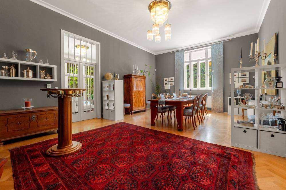 Geräumiger Wohn-Essbereich mit elegantem Holztisch, Parkettboden und großem Orientteppich.