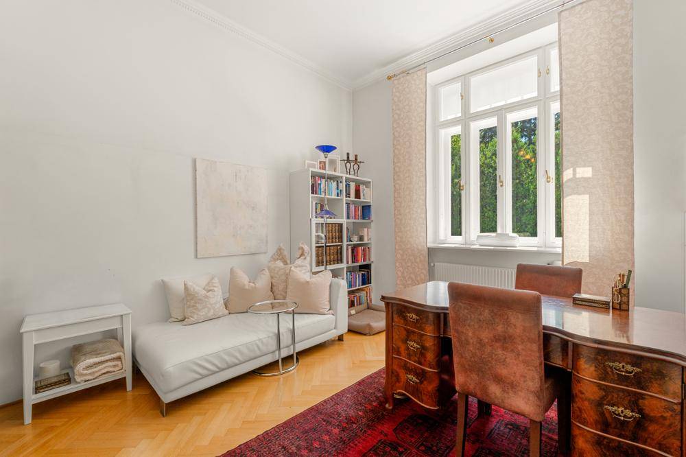 Elegantes Arbeitszimmer mit klassischem Schreibtisch, Bücherregal und gemütlicher Liege.