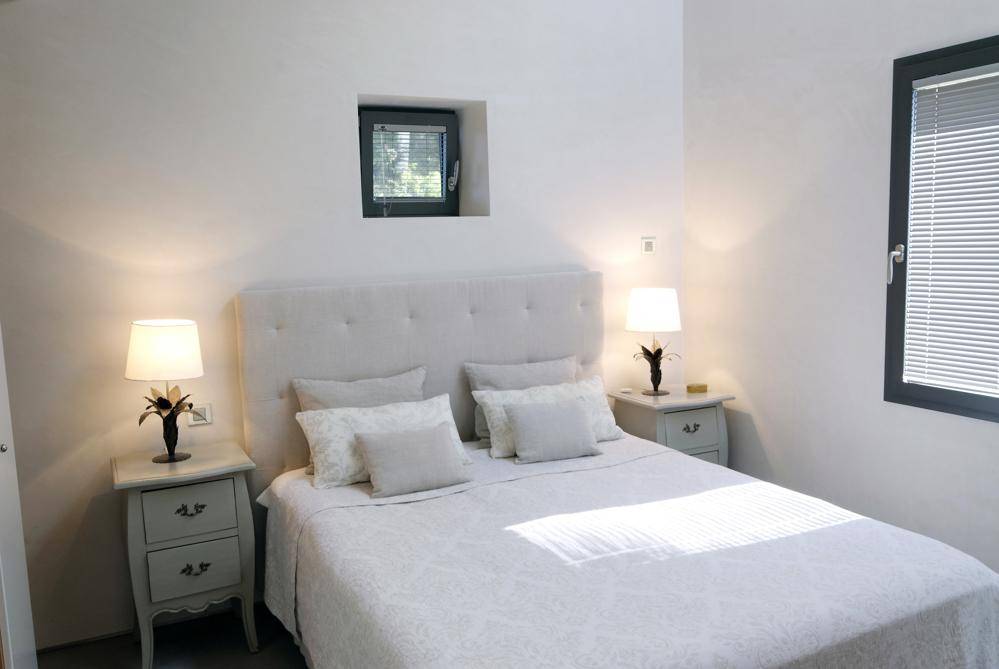 Ruhiges Schlafzimmer mit Doppelbett, Nachttischen und Fenster für natürliches Licht.