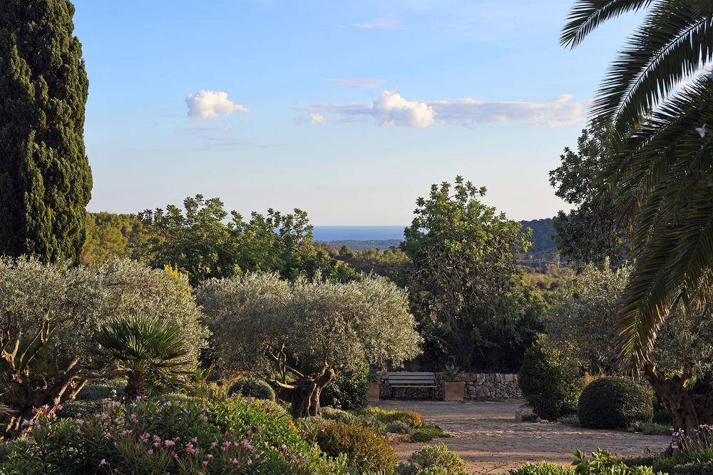 Weitläufiger Blick über die mediterrane Landschaft bis zum Meer am Horizont.