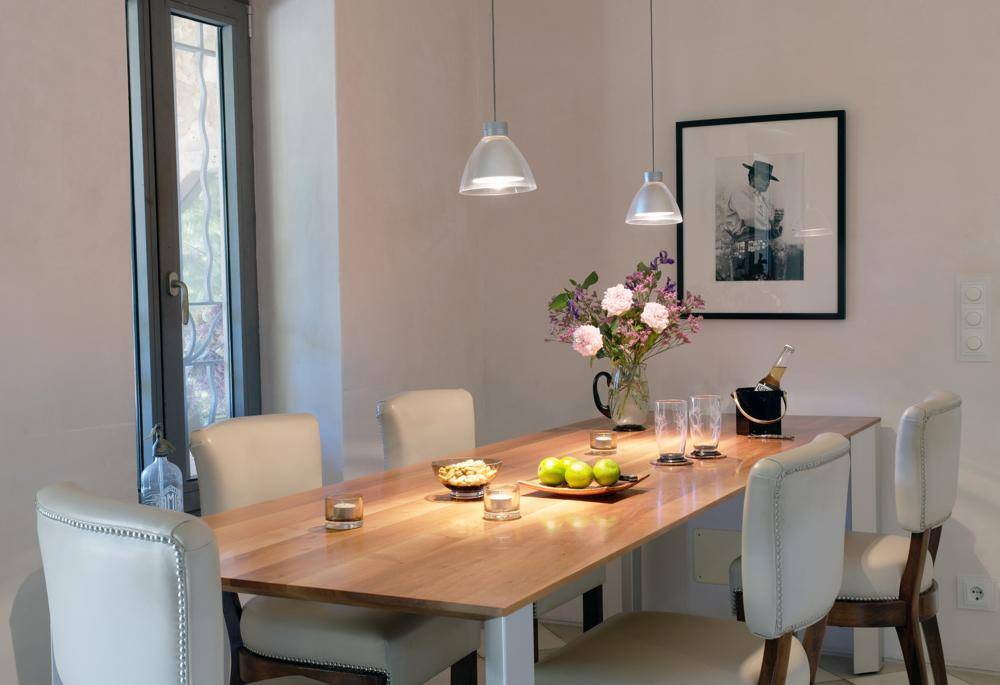 Eleganter Essbereich mit Holztisch, bequemen Stühlen und stilvoller Beleuchtung.