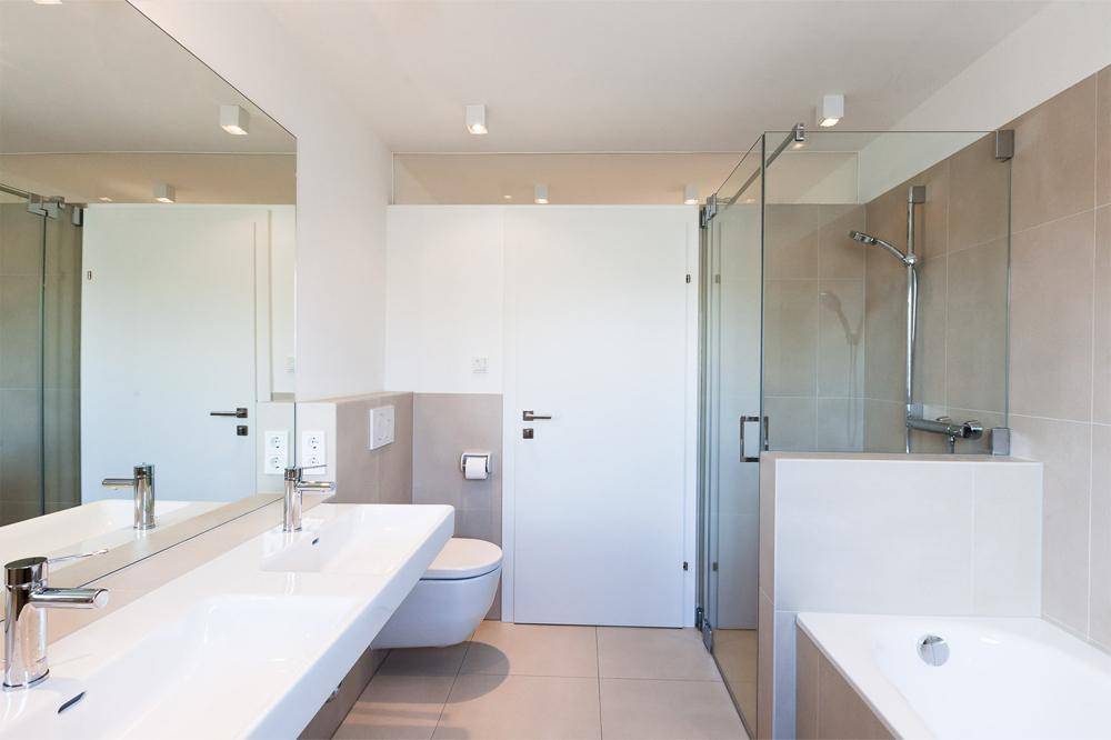 Modernes Badezimmer mit Doppelwaschbecken, begehbarer Dusche und Badewanne.