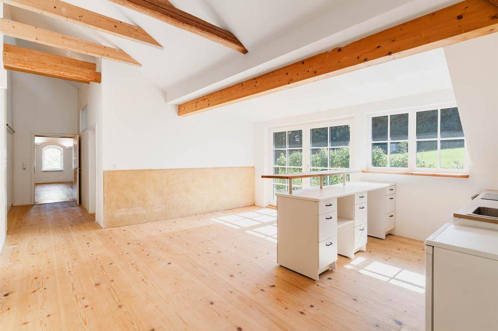 Geräumiger, heller Raum mit Holzbalken und großen Fenstern, ideal für individuelle Gestaltung.
