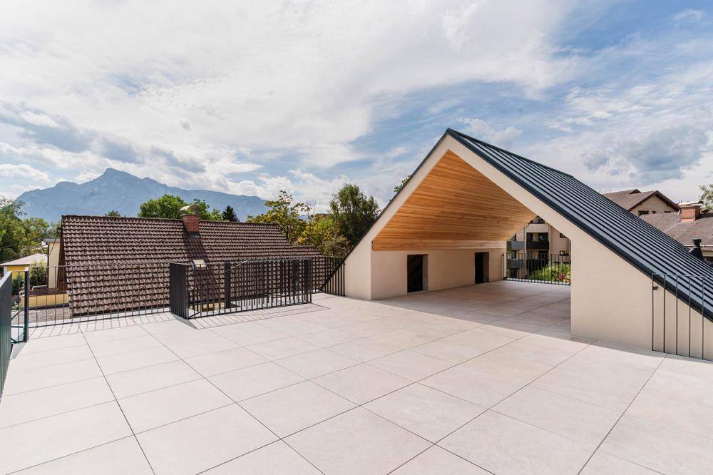 Weitläufige Dachterrasse mit beeindruckendem Bergblick und moderner Architektur.