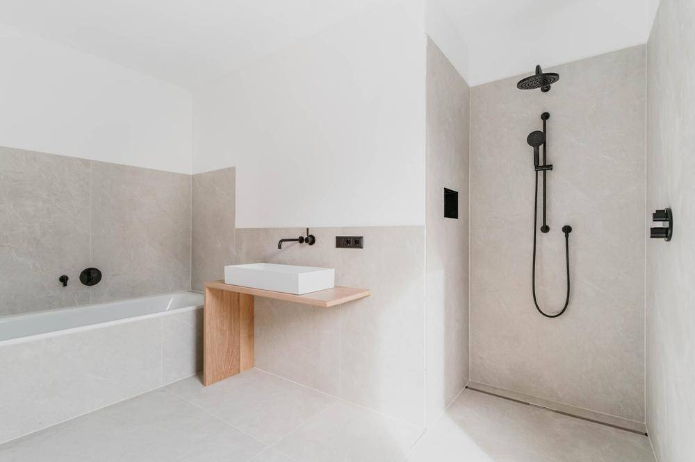 Modernes Badezimmer mit Badewanne, begehbarer Dusche und minimalistischem Design.