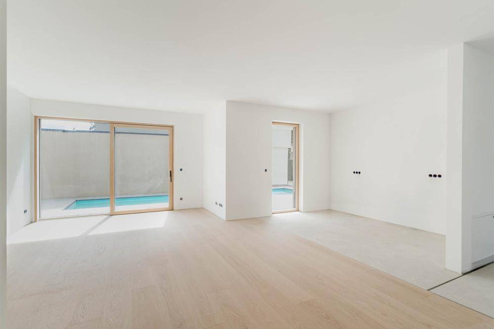Heller Raum mit Holzboden und großen Schiebetüren zum privaten Poolbereich.