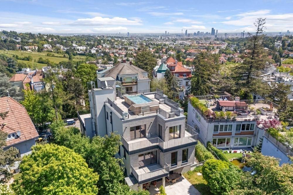 Weitläufige Ansicht der modernen Wohnanlage mit Dachpool und Blick auf die umliegende Stadtlandschaft.