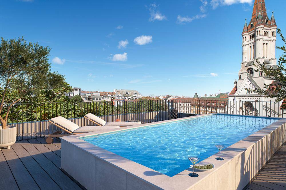 Exklusive Dachterrasse mit Infinity-Pool, Sonnenliegen und malerischem Blick auf die Stadt und Kirchtürme.