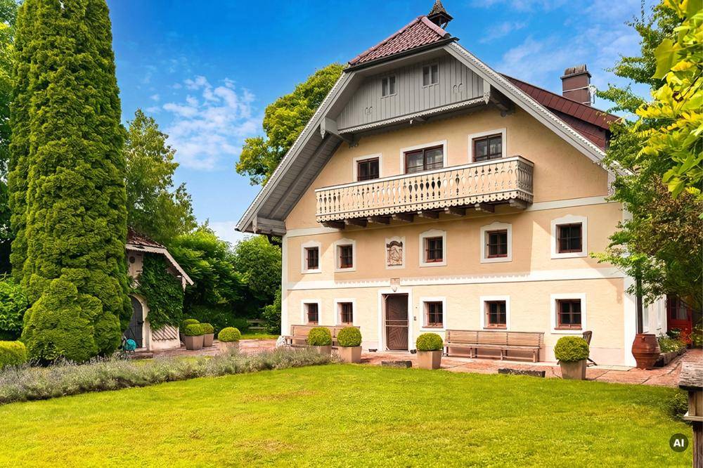 Charmantes Landhaus mit traditioneller Fassade, Balkon und einem gepflegten Vorgarten mit Sitzgelegenheiten.