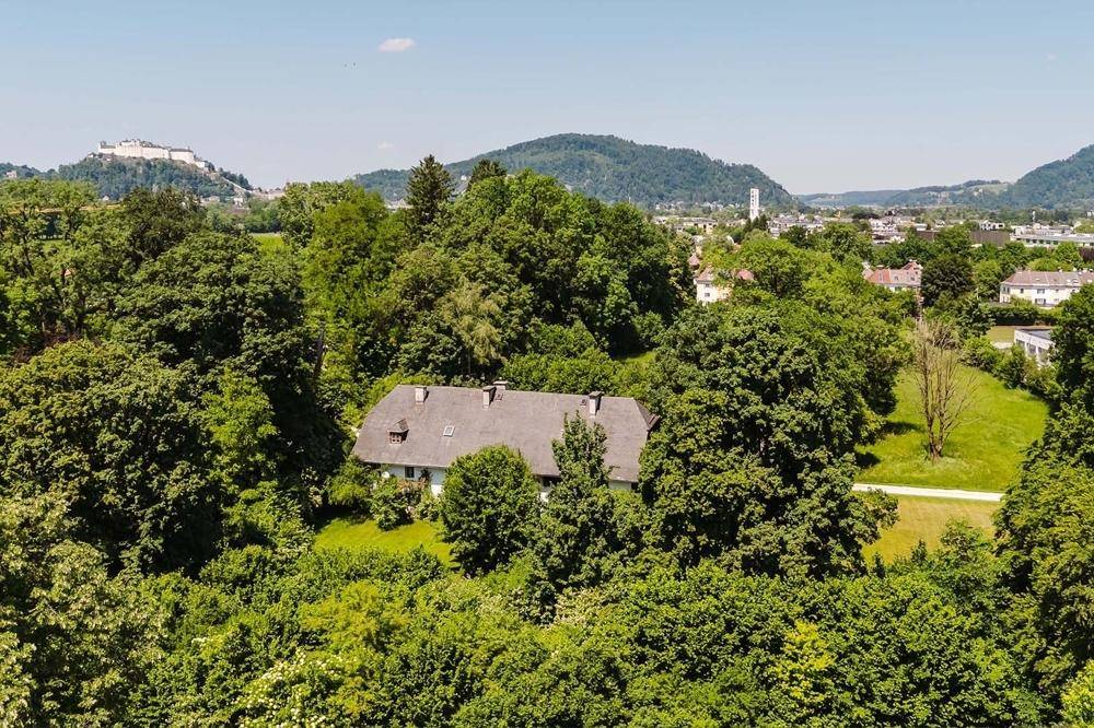 Idyllisches Haus umgeben von dichtem Grün, mit weitem Blick auf die Stadt und die historische Festung.