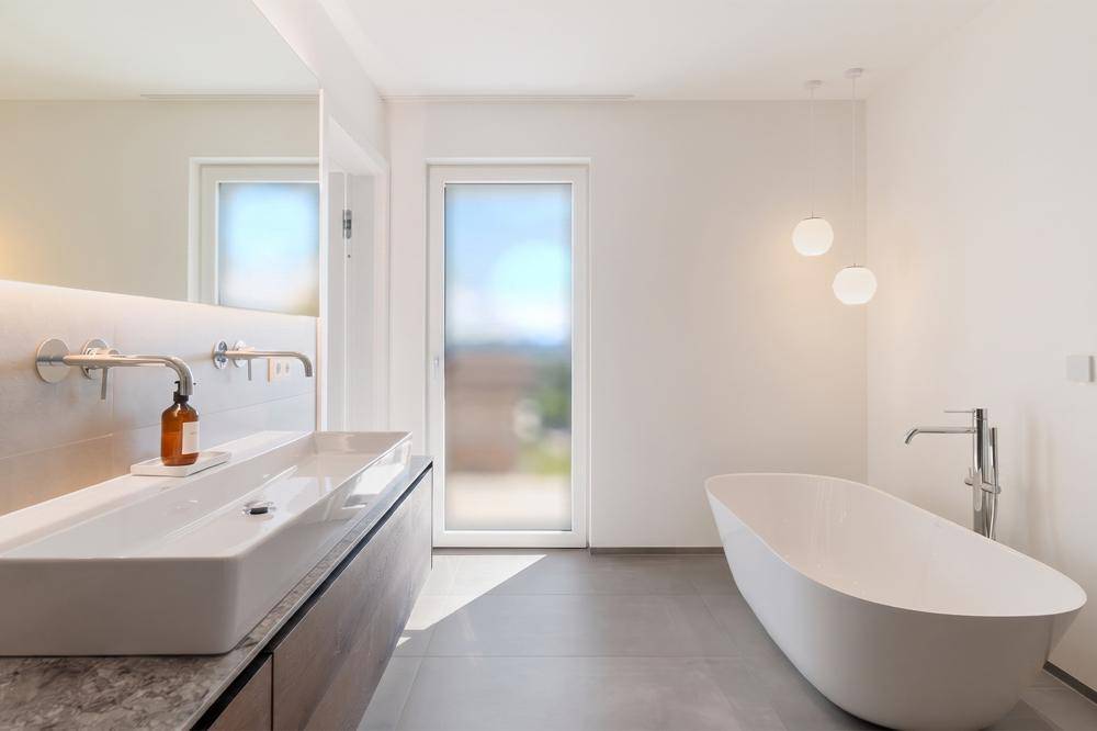 Das Hauptbadezimmer mit freistehender Badewanne ...