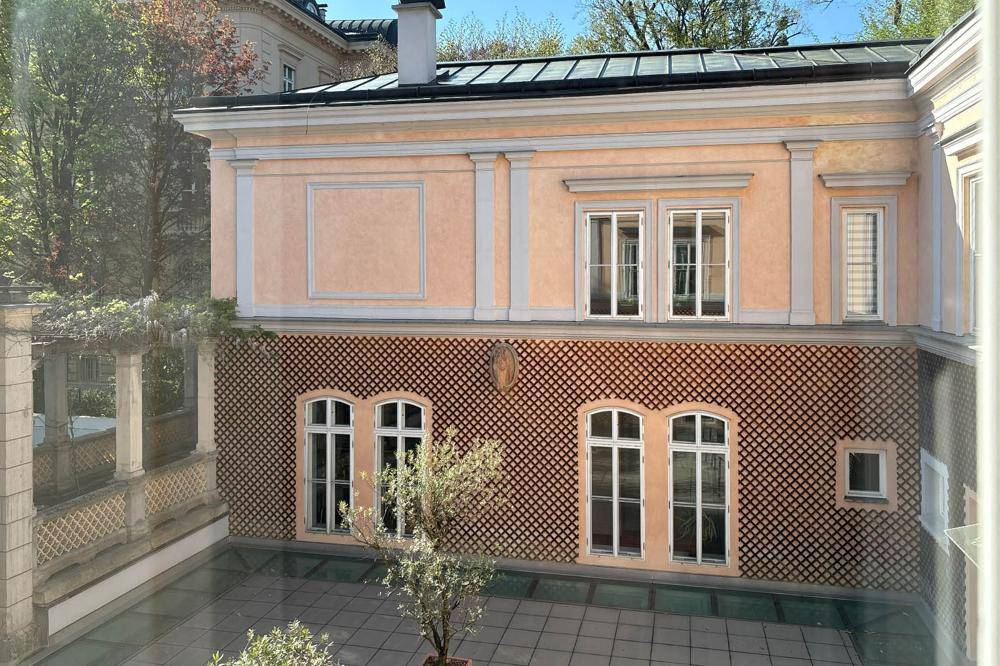 Blick aus dem Fenster auf einen gepflasterten Innenhof und die historische Gebäudefassade.
