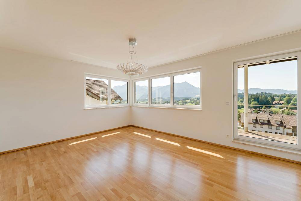 Geräumiges Schlafzimmer mit Holzboden, vielen Fenstern und herrlichem Bergblick.