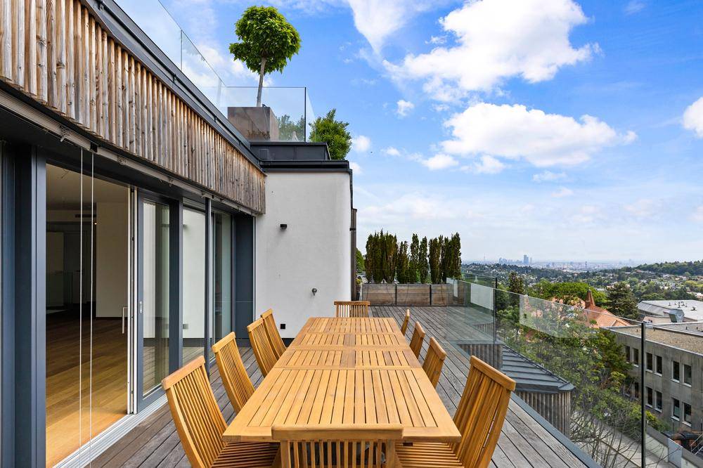 Große Terrasse mit Holzesstisch und Stühlen, ideal für Mahlzeiten im Freien mit Stadtblick.