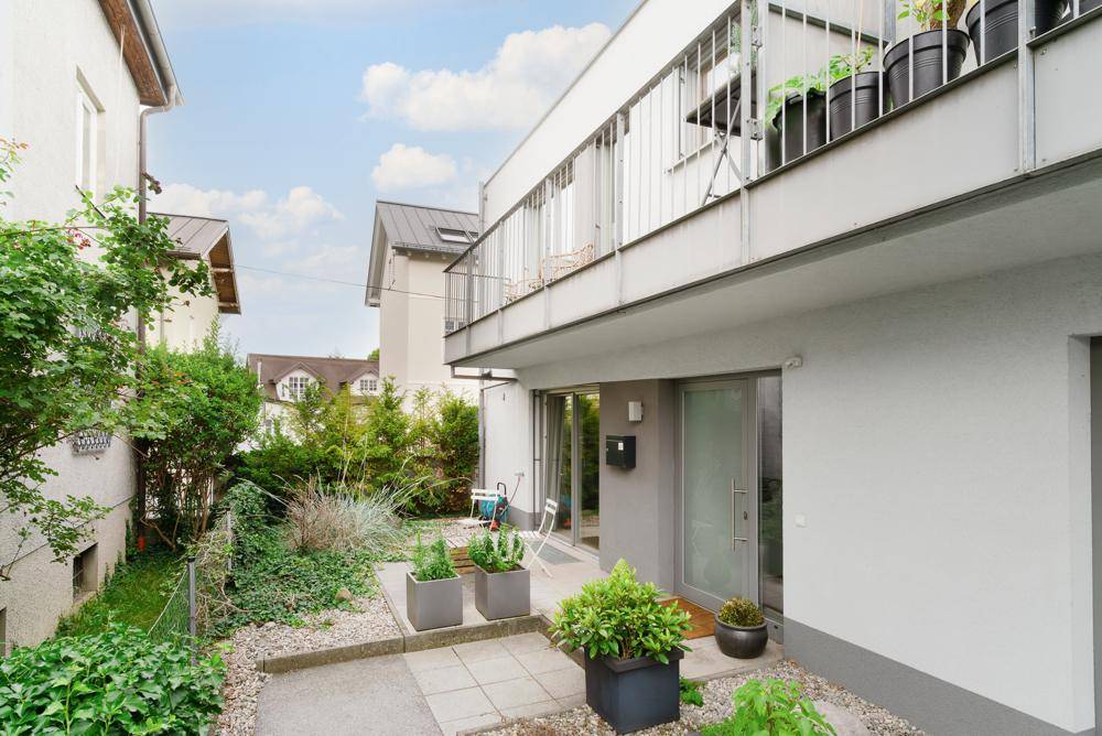 Kleiner, gepflegter Gartenbereich mit Pflanzen, Kies und Zugang zum Gebäude.