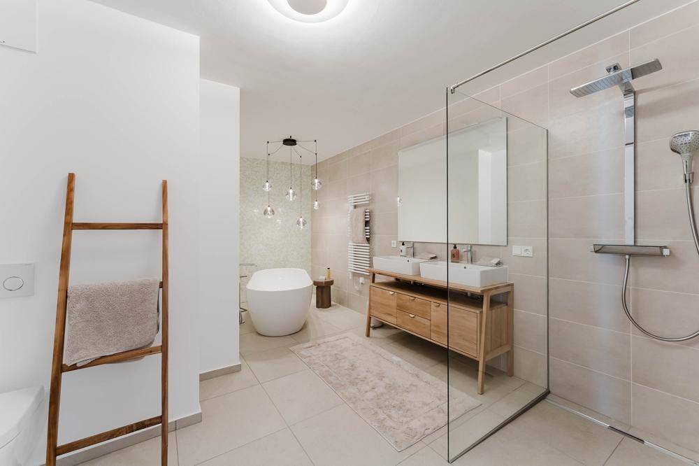 Modernes Badezimmer mit freistehender Badewanne, Doppelwaschbecken und großer Dusche.