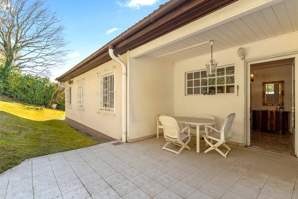 Gepflasterte Terrasse mit Gartenmöbeln und direktem Zugang zum Haus und Garten.