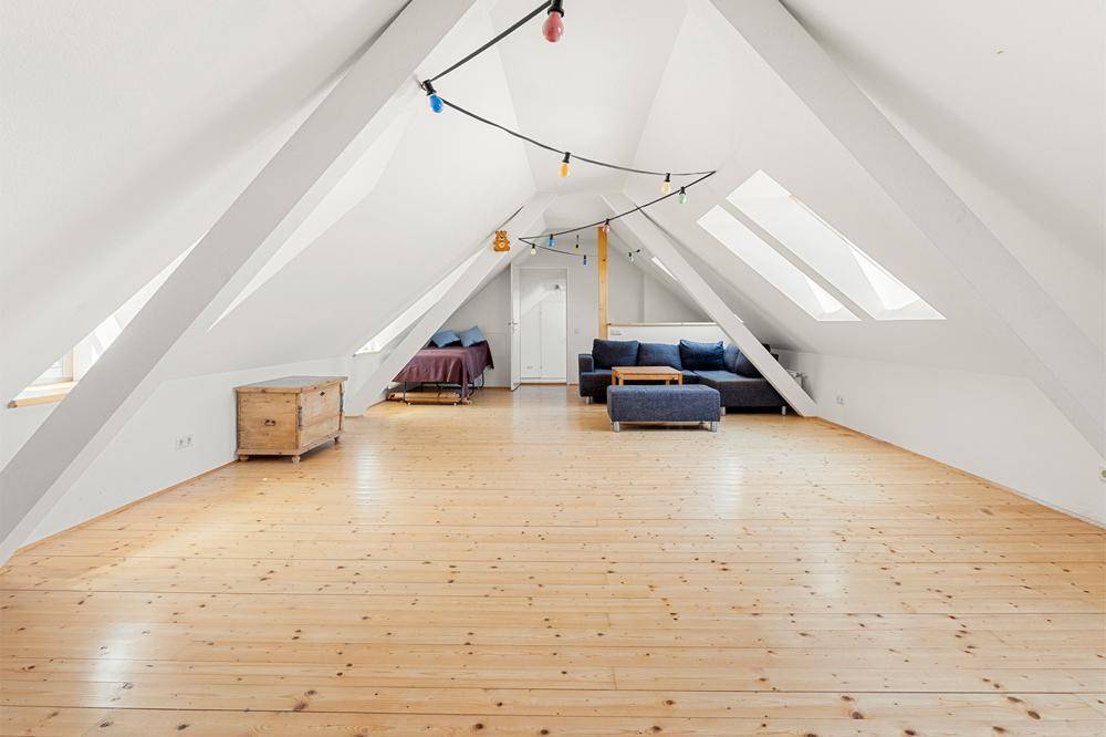Ausgebautes Dachgeschoss mit Holzdielenboden, Dachschrägen und gemütlicher Sitzecke.