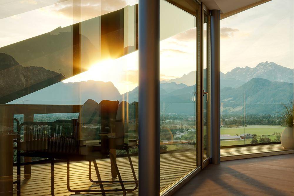 Sonniger Balkon mit Sitzgelegenheiten und spektakulärem Blick auf die umliegende Berglandschaft.