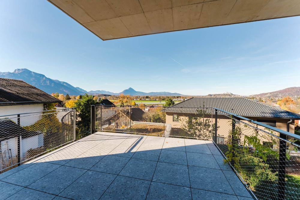 Geräumige Terrasse mit Fliesenboden und weitem Blick auf die umliegende Berglandschaft.