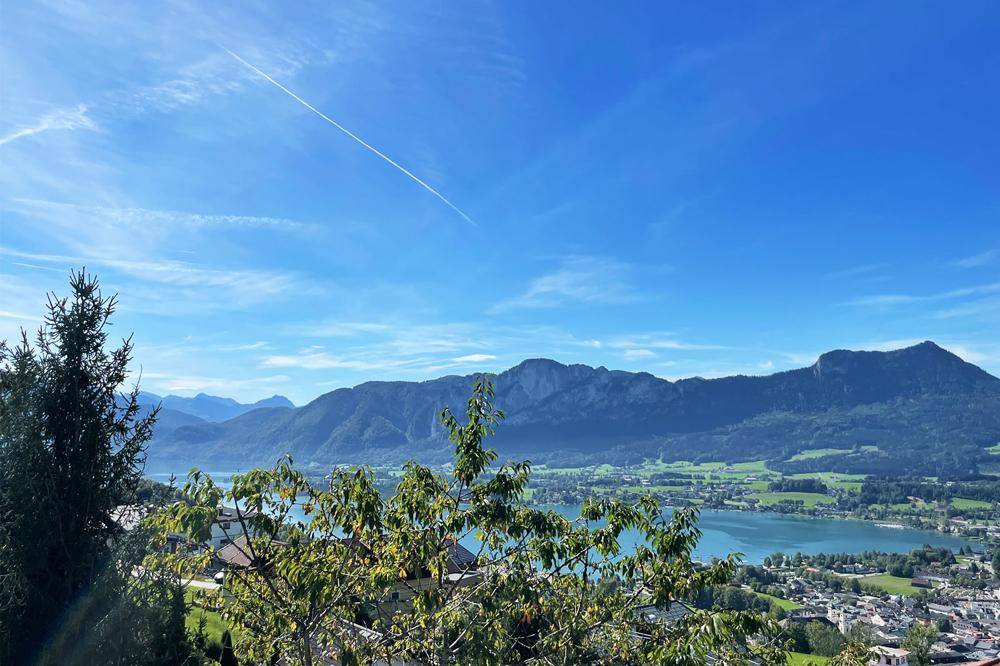 Panoramablick auf die malerische Seen- und Berglandschaft unter blauem Himmel.