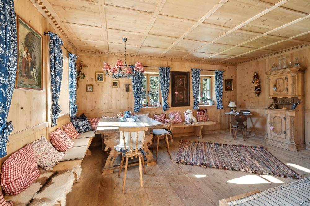 Gemütlicher Essbereich im traditionellen Stil mit viel Holz, großem Esstisch und karierten Vorhängen.