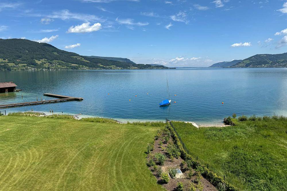 Malerischer Seeblick mit grüner Rasenfläche und privatem Zugang zum Wasser.