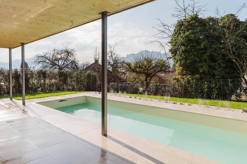 Außenbereich mit Pool, überdachter Terrasse und Blick auf die umliegende Landschaft.