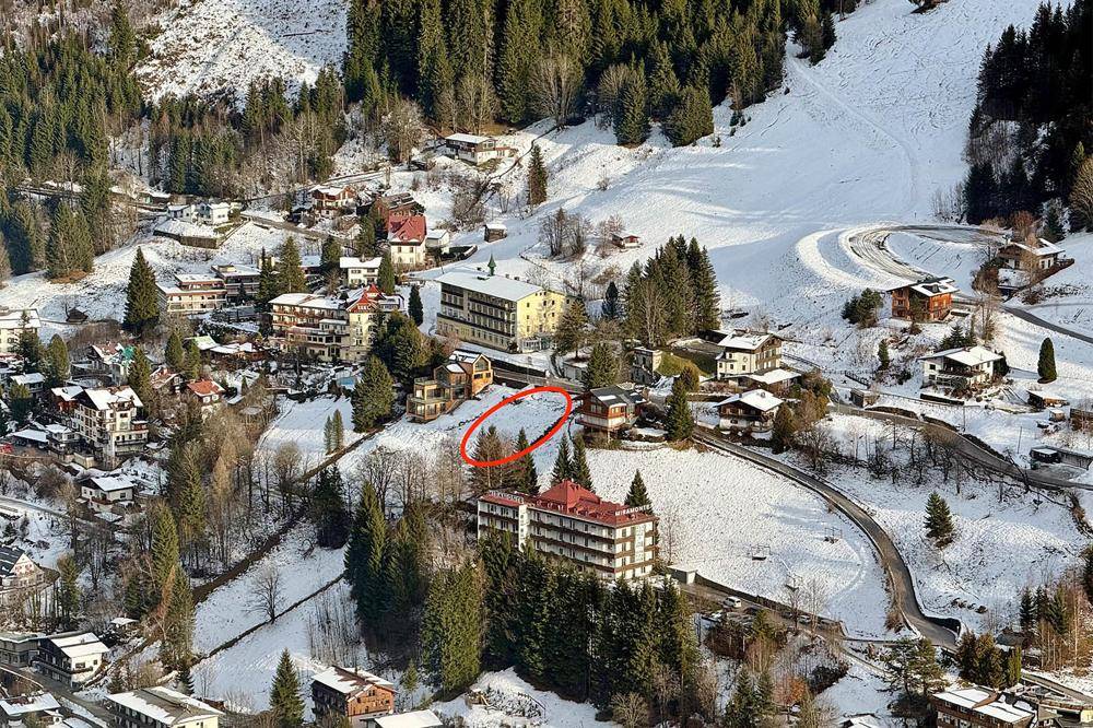 Luftaufnahme eines schneebedeckten Dorfes in den Bergen, mit einem rot eingekreisten Bereich.