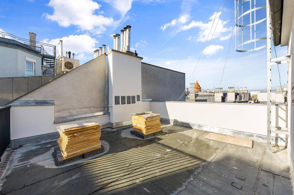Dachterrasse mit Blick über die Dächer der Stadt, bereit für die Gestaltung als Außenbereich.