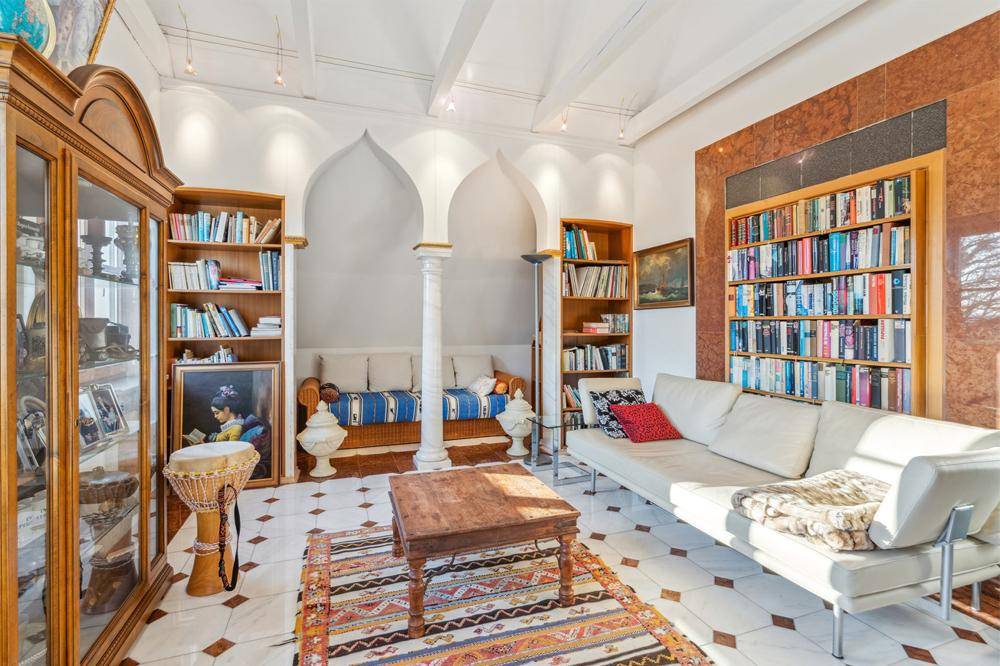 Gemütliche Bibliothek mit orientalischem Flair, Bücherregalen und bequemen Sitzgelegenheiten.