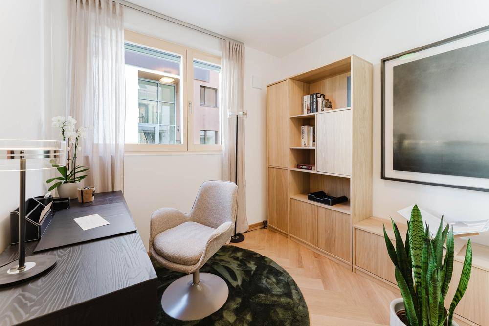 Modernes Arbeitszimmer mit Holzregal, Schreibtisch und Blick ins Grüne.