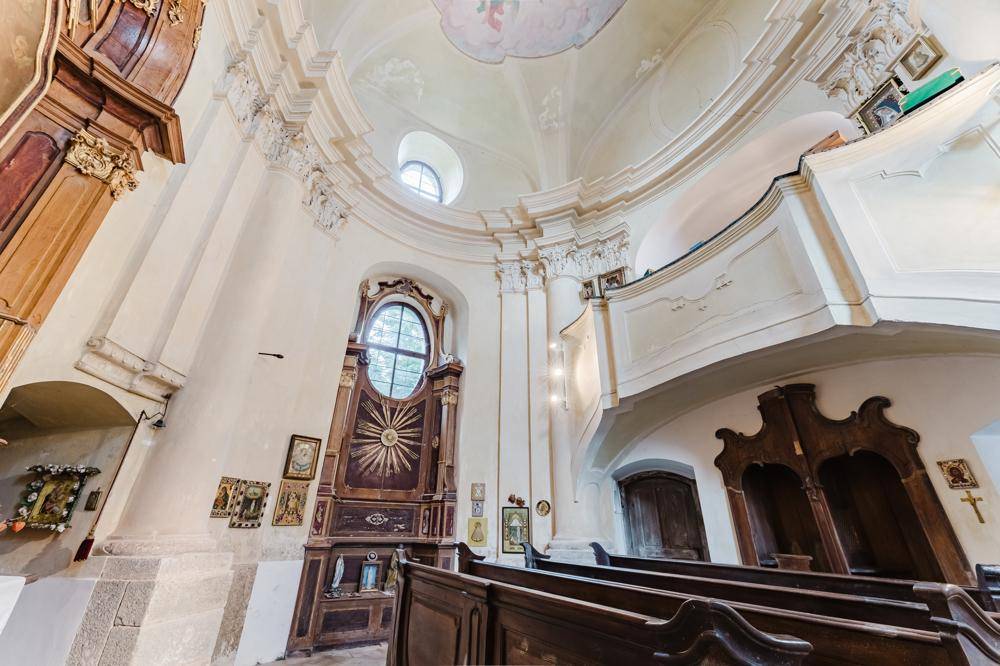 Historischer Kapellenraum mit hohen Gewölbedecken, kunstvollen Holzbänken und religiösen Verzierungen.