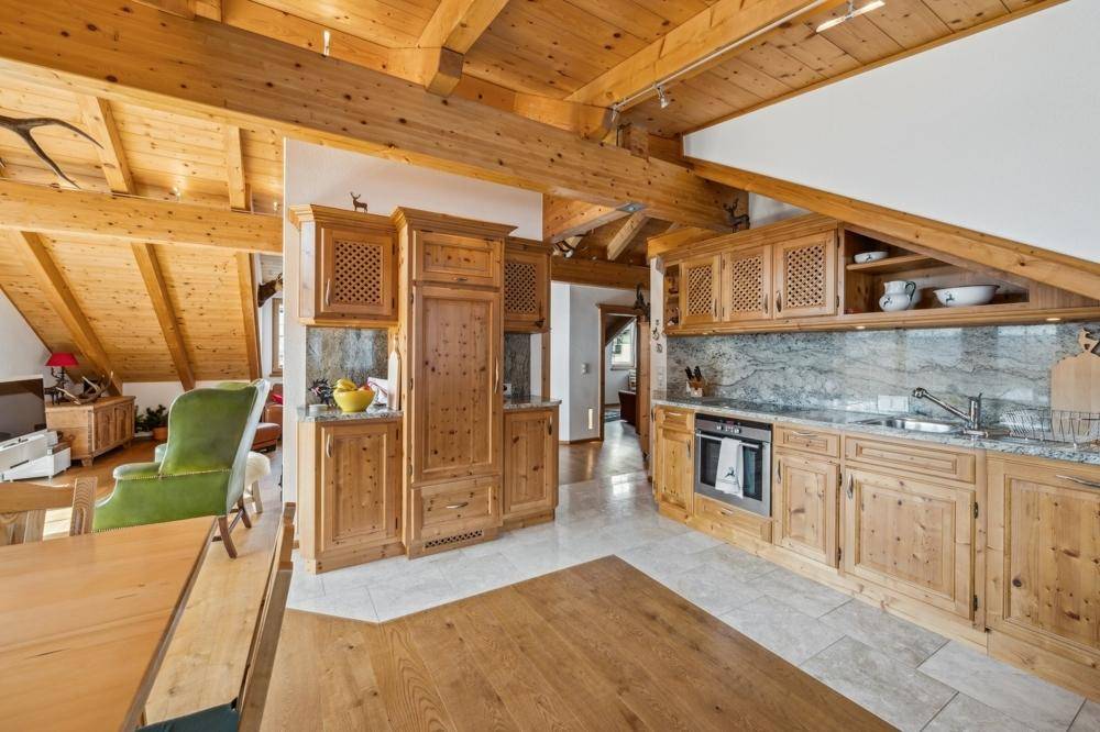 Traditionelle Holzküche mit Granitarbeitsplatten, integrierten Geräten und rustikalen Details.